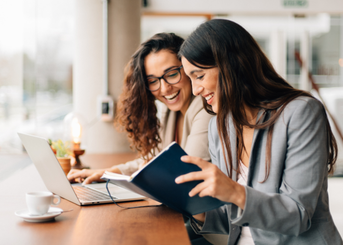 people looking at book and laptop on Sage Intacct page