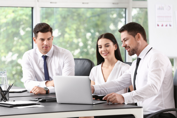 Group of people in office looking at laptop