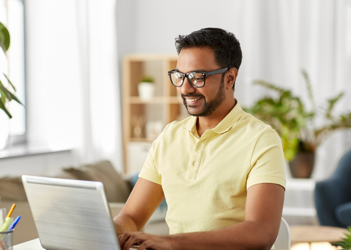 Man smiling whilst using computer