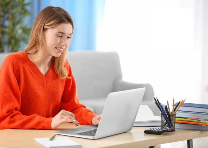 Woman using computer whilst smiling 