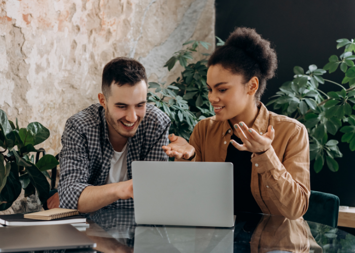 woman and man looking at automation yooz webinar on laptop