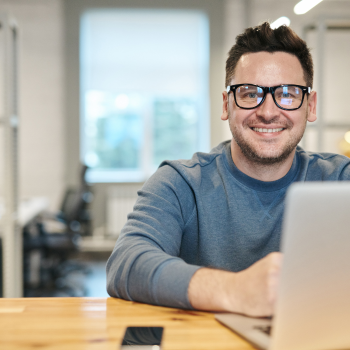 man looking at the camera and screen showing Sage 200 